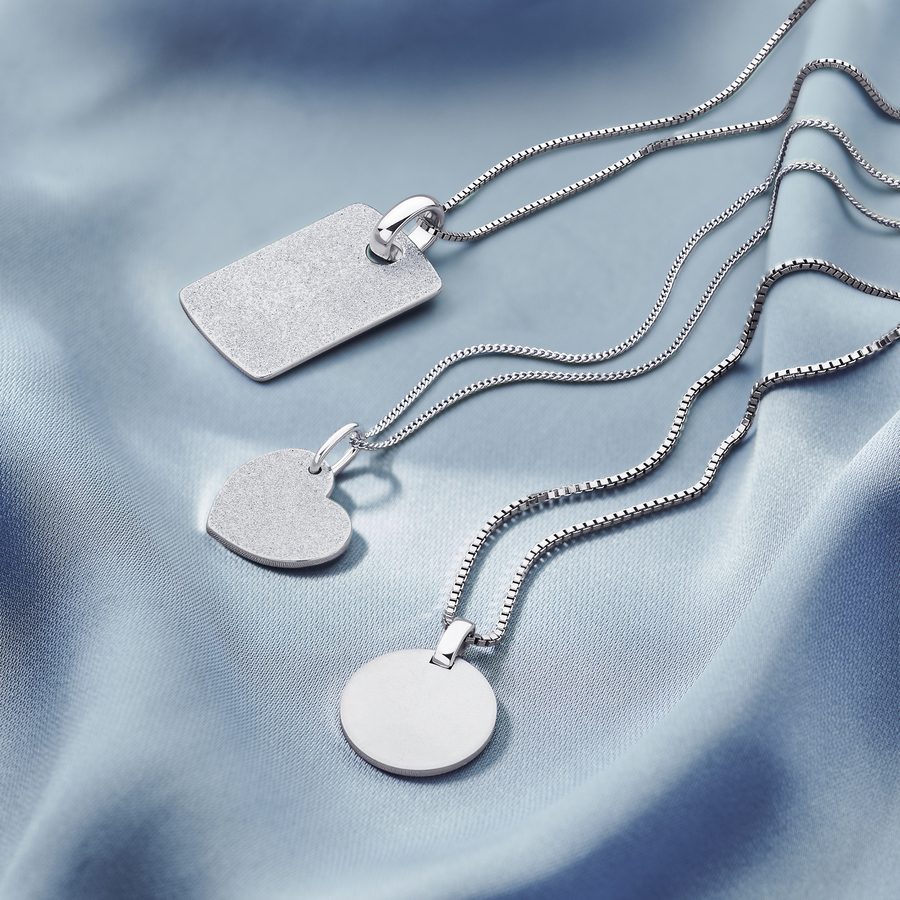 Zilveren colliers met hangers op blauwe zijde