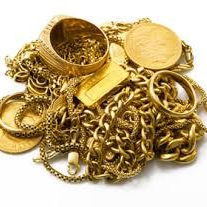 Oude gouden sieraden, kettingen en munten bij elkaar op een witte ondergrond